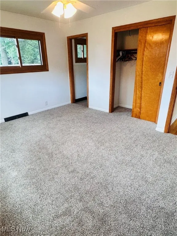 Unfurnished bedroom featuring carpet flooring, a closet, and ceiling fan
