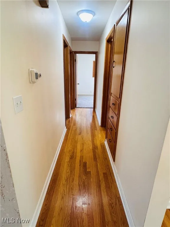 Hallway with light wood finished floors and baseboards