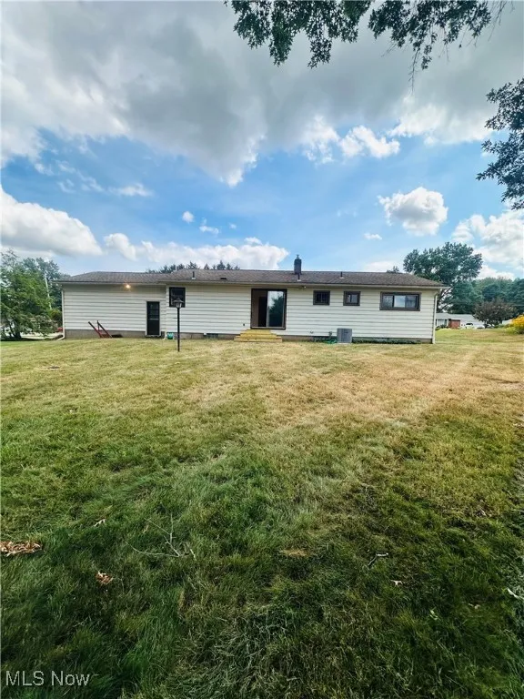 Back of property featuring a lawn