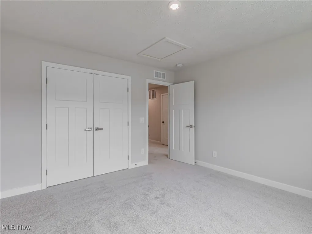 Another view of the second floor bedroom with double closet and carpet flooring