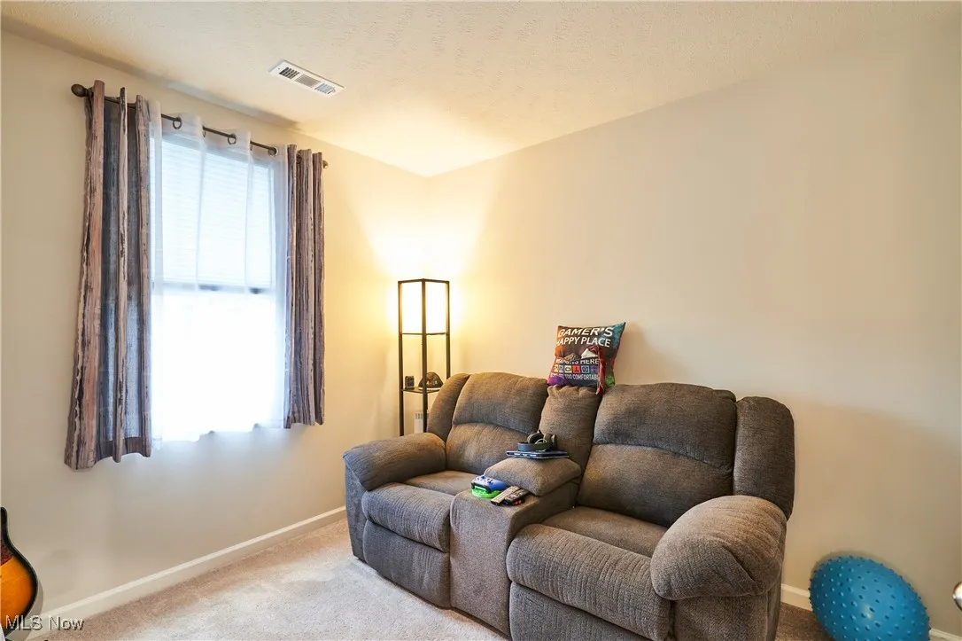 Sitting room featuring carpet flooring and baseboards