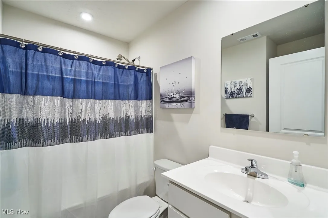 Full bath featuring vanity, shower / bath combination with curtain, and recessed lighting
