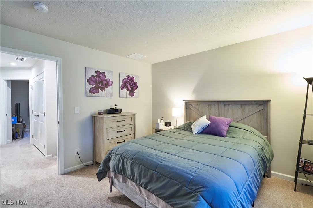 Bedroom featuring light carpet