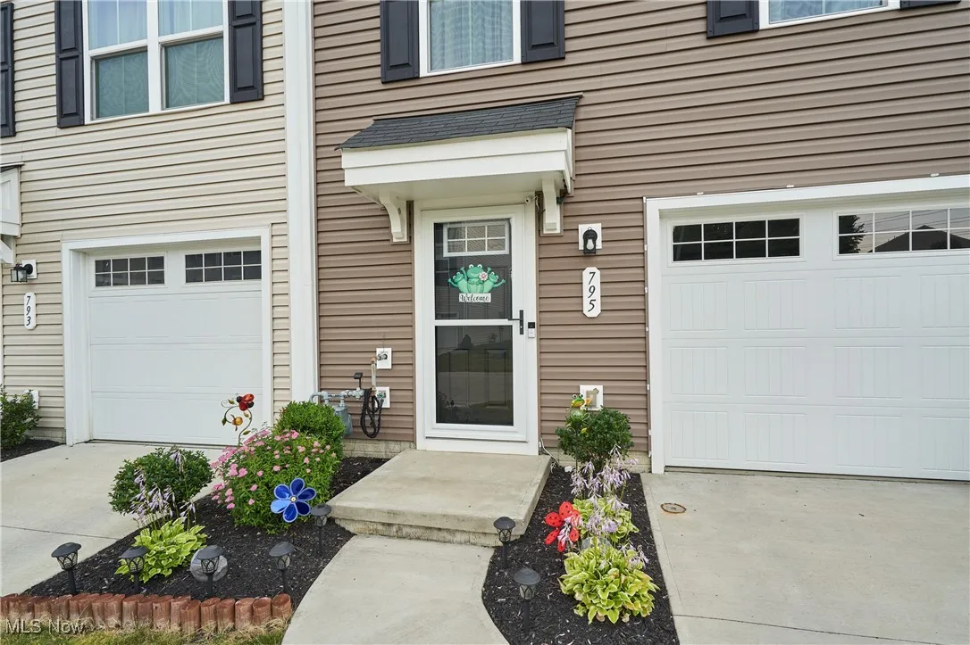 Property entrance with a garage and concrete driveway
