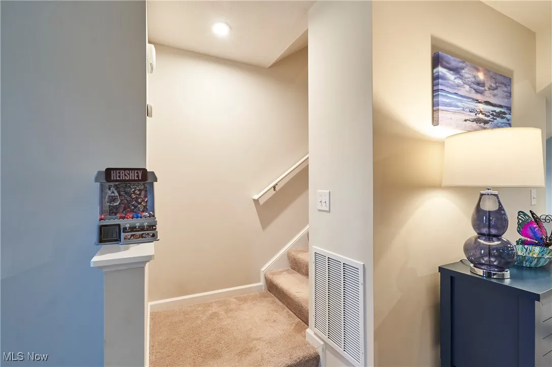 Stairway with carpet floors and recessed lighting