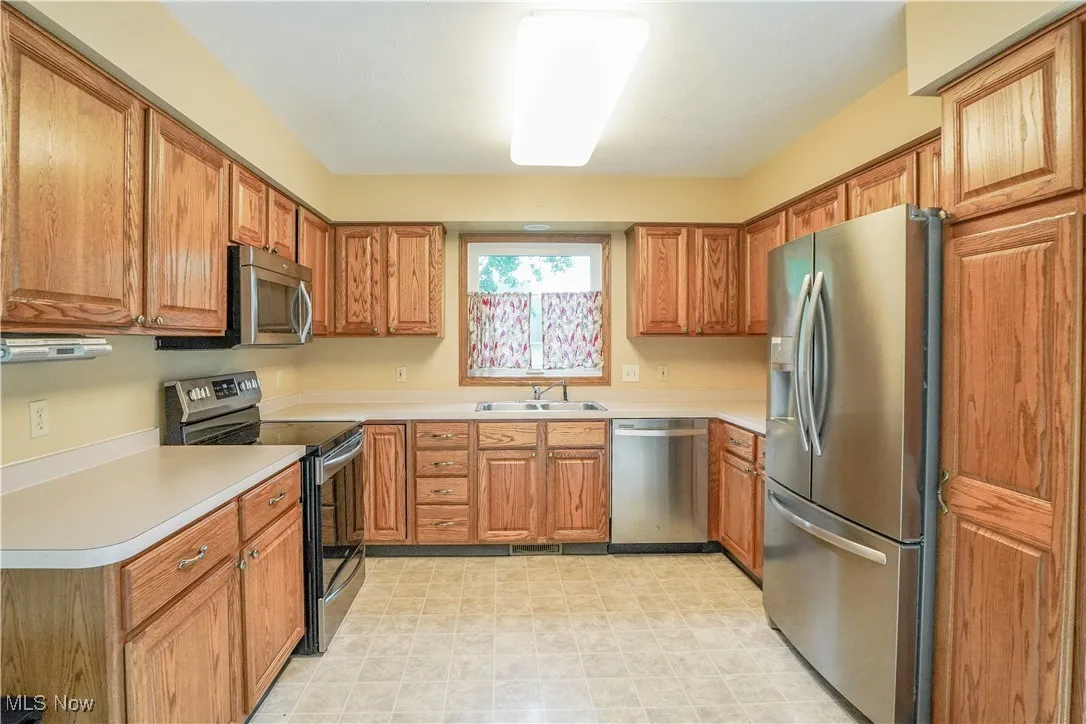 Kitchen featuring stainless steel appliances, cabinetry, and light countertops
