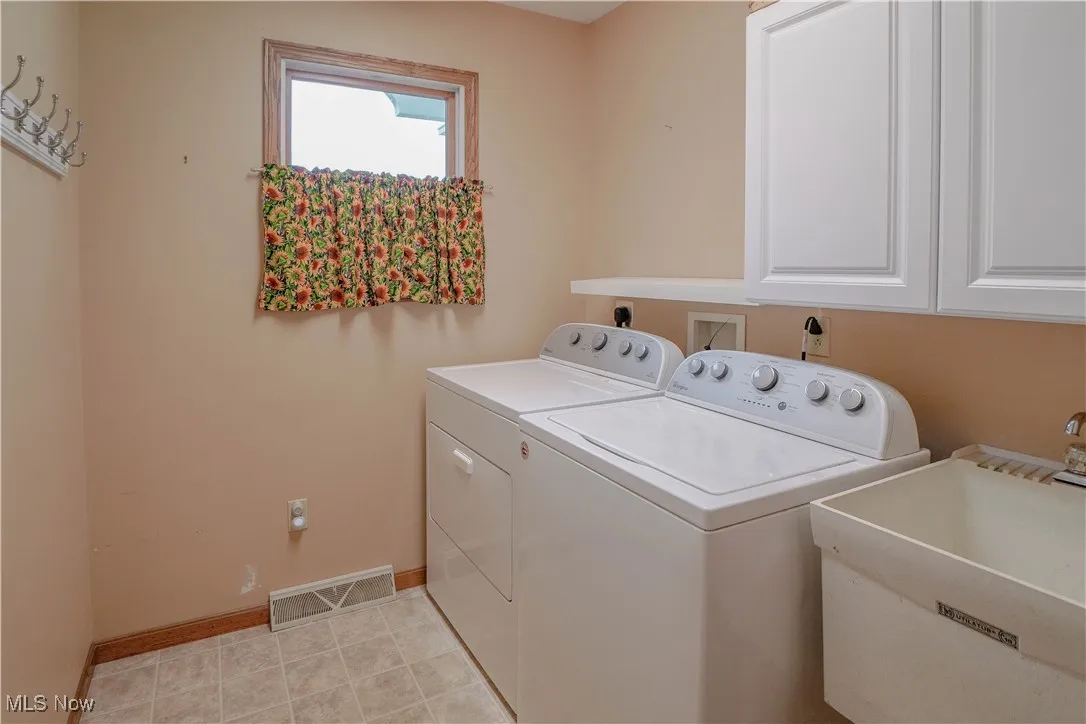 Laundry area with independent washer and dryer and cabinet space