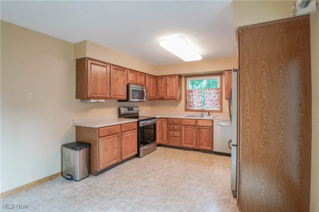 Kitchen featuring stainless steel appliances, light countertops, and cabinets