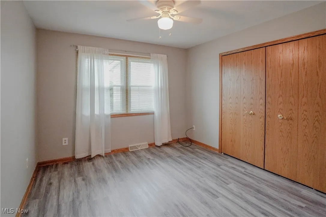 Unfurnished bedroom featuring light wood-type flooring, a closet, and ceiling fan