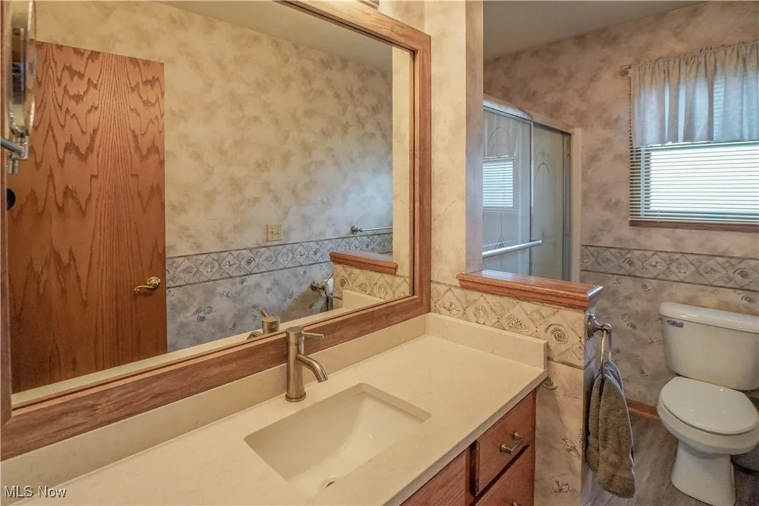 Full bathroom with vanity, a shower with door