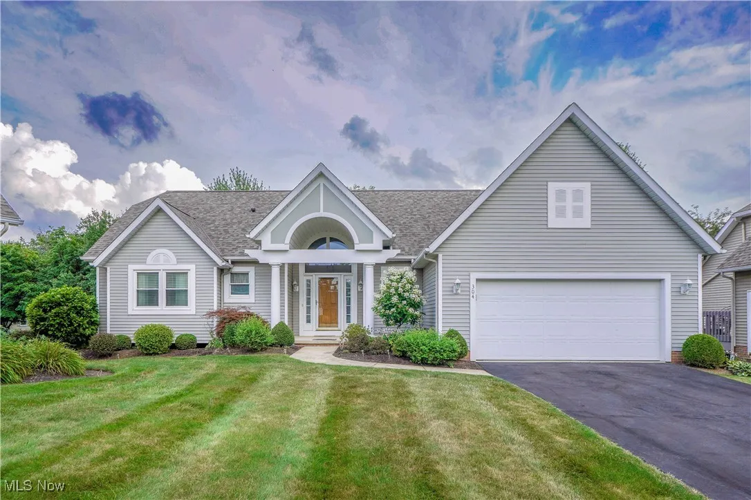 View of front of house featuring asphalt driveway, a front lawn, and a shingled roof