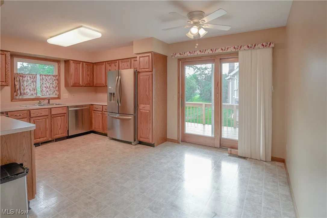 Kitchen featuring appliances with stainless steel finishes, plenty of natural light, light countertops, and ceiling fan