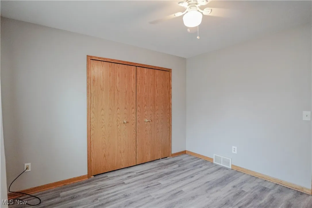 Unfurnished bedroom with light wood-type flooring, a closet, and ceiling fan