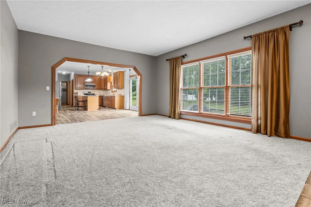 View of carpeted family room open from the eat-in kitchen