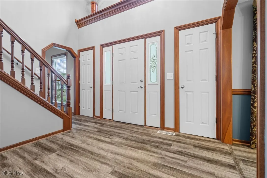 Foyer featuring LVT floors and stairs to second level.  Coat closets on either side of the front door