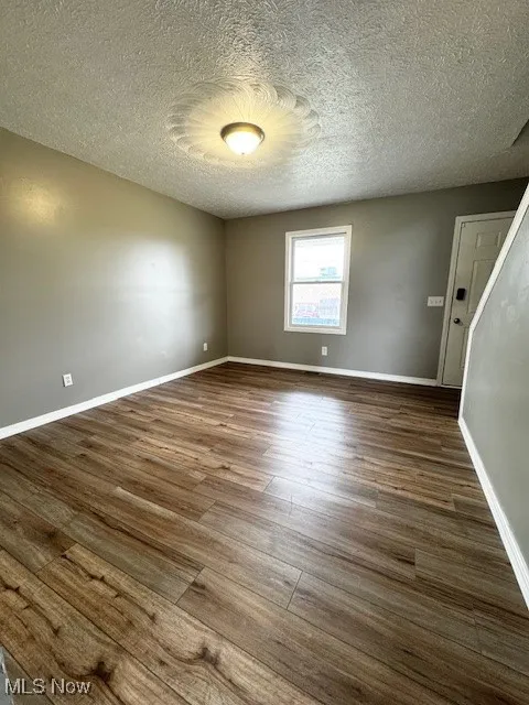 Unfurnished room with LVT flooring and a textured ceiling