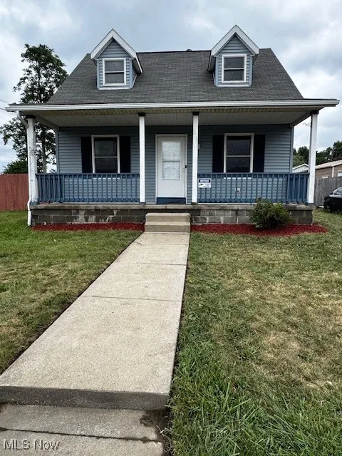View of front of house featuring a porch and a shingled roof