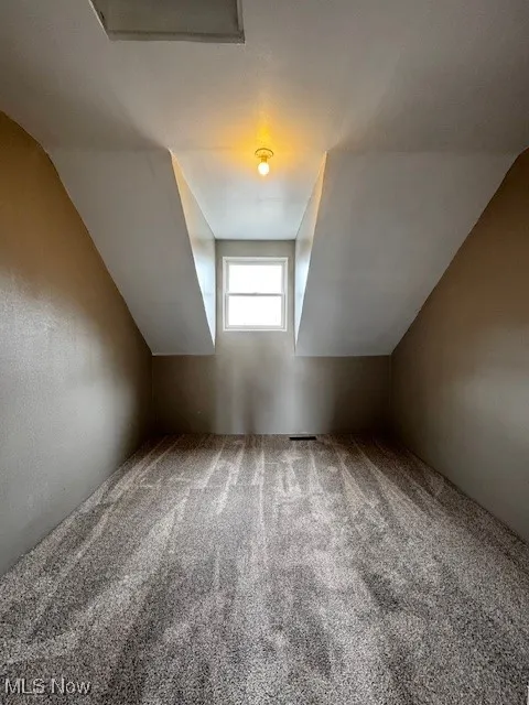 Bonus room featuring new carpet and lofted ceiling