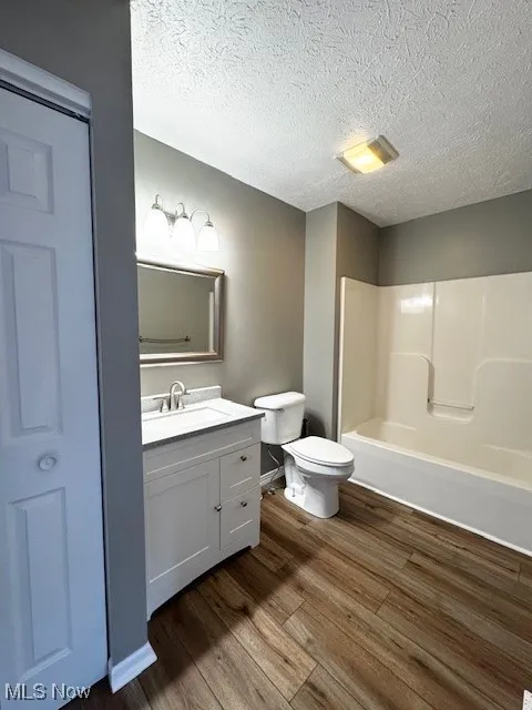 Full bathroom featuring vanity, LVT flooring, and shower / washtub combination