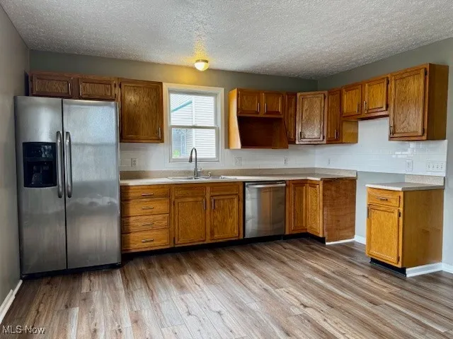 Kitchen with stainless steel appliances, LVT floors,plenty of cabinet space, and tile backsplash