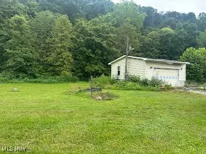 View of grassy yard with a view of trees