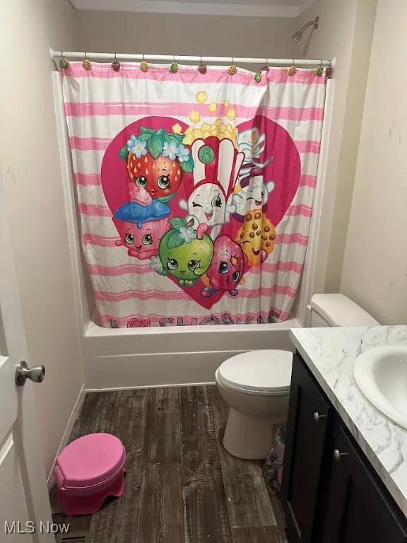 Bathroom featuring shower / tub combo, wood finished floors, and vanity
