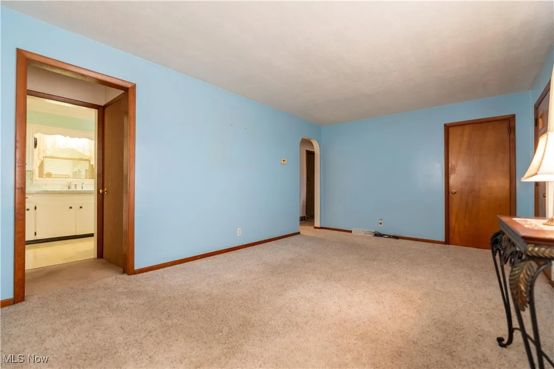 Unfurnished living room with carpet and arched walkways