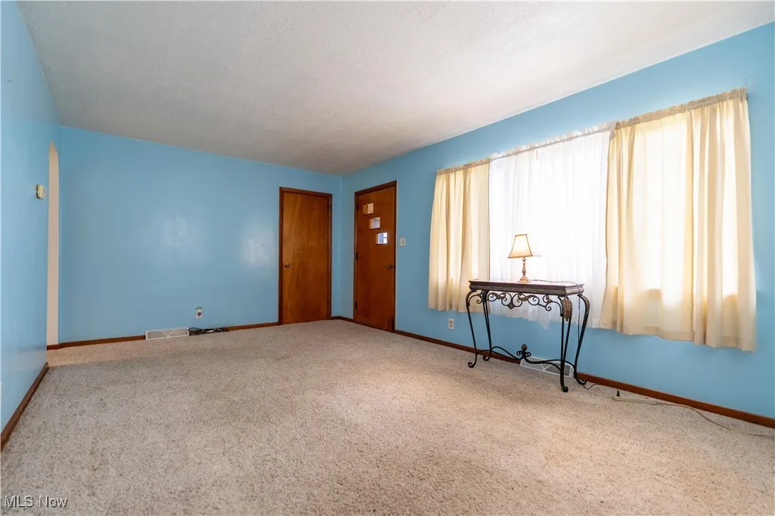 Carpeted living room with healthy amount of natural light