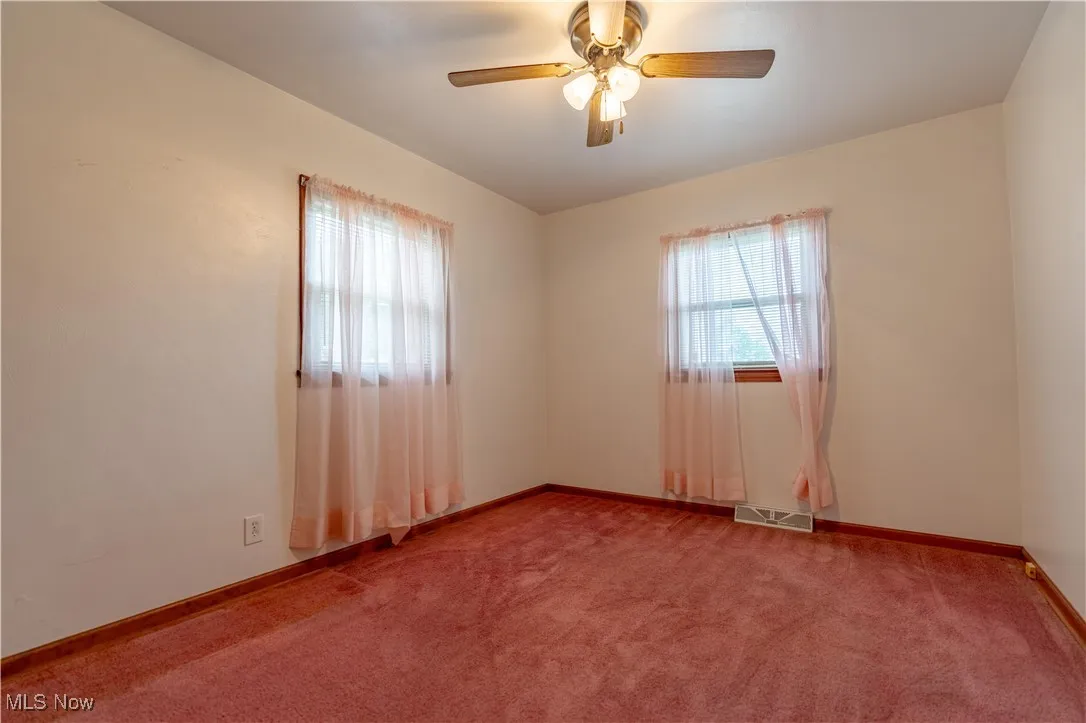 Empty room with carpet floors and ceiling fan
