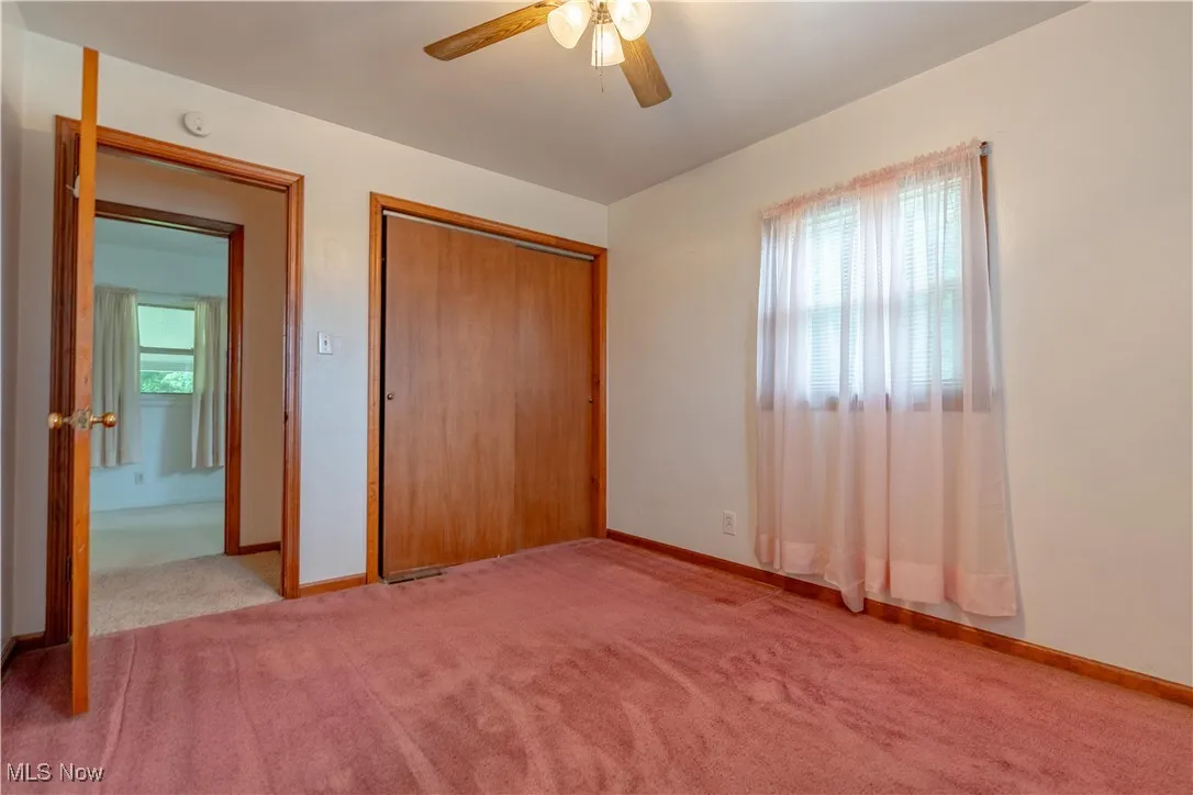Unfurnished bedroom with carpet flooring, a closet, and a ceiling fan