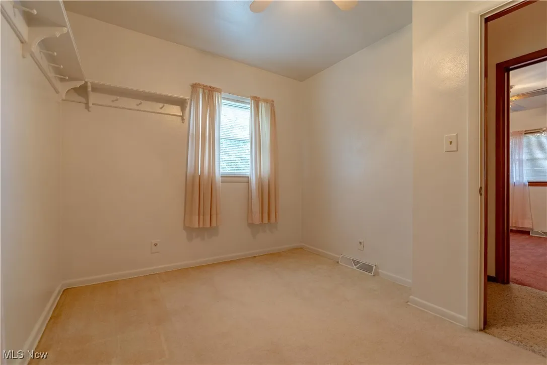 Unfurnished bedroom with carpet and ceiling fan