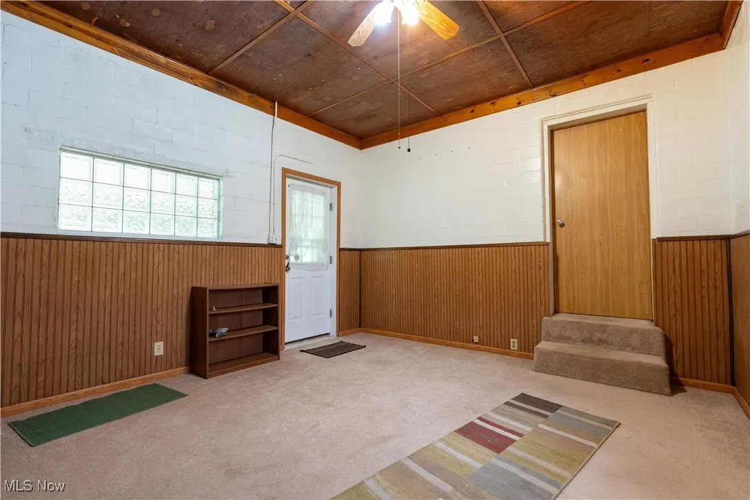 Breezeway with ceiling fan and light carpet