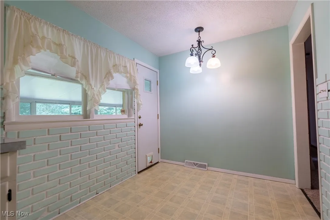Kitchen with tile patterned floors, a textured ceiling, and a chandelier
