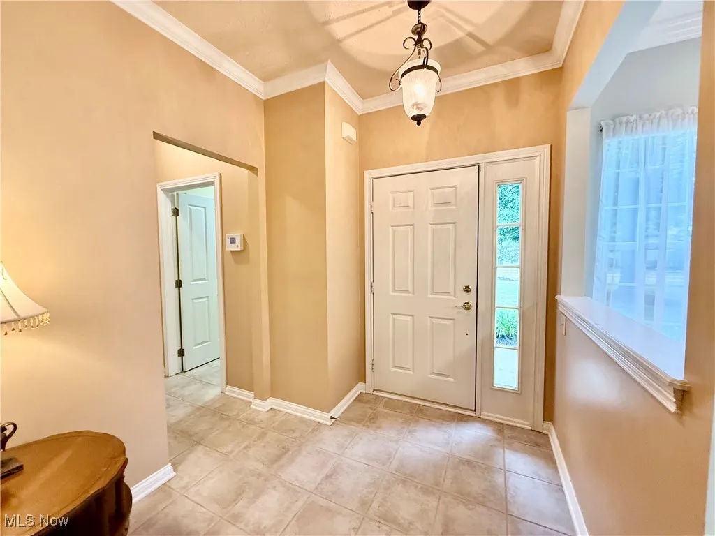 Entryway featuring ornamental molding and light tile ceramic floors