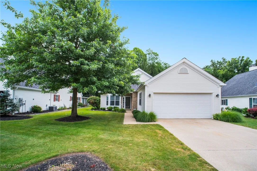 View of front of property with a garage, a front yard, and concrete driveway