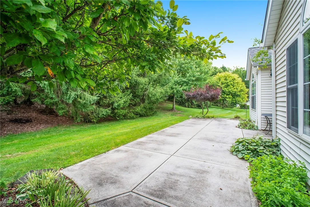 View of grassy yard featuring a patio area