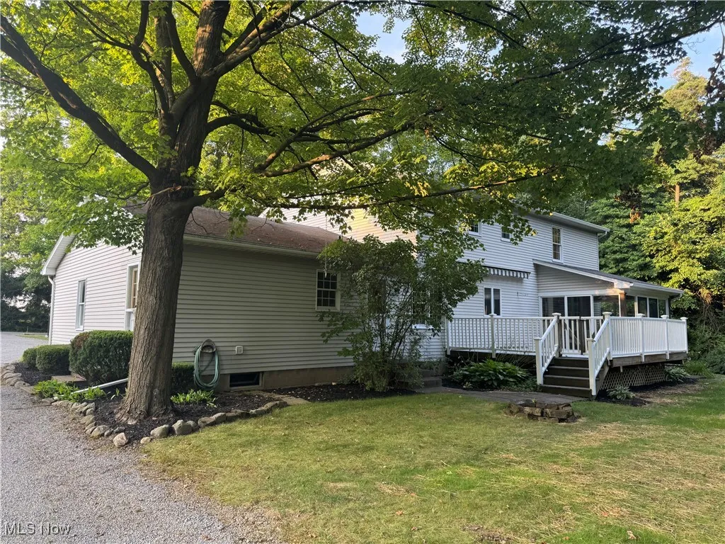 Rear view of house featuring a lawn and a wooden deck