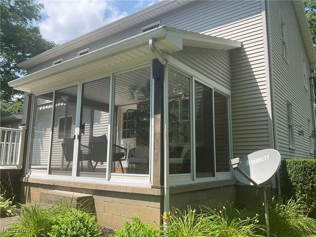 View of property exterior featuring a sunroom