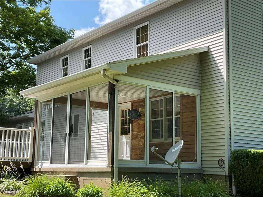 Rear view of property featuring a sunroom