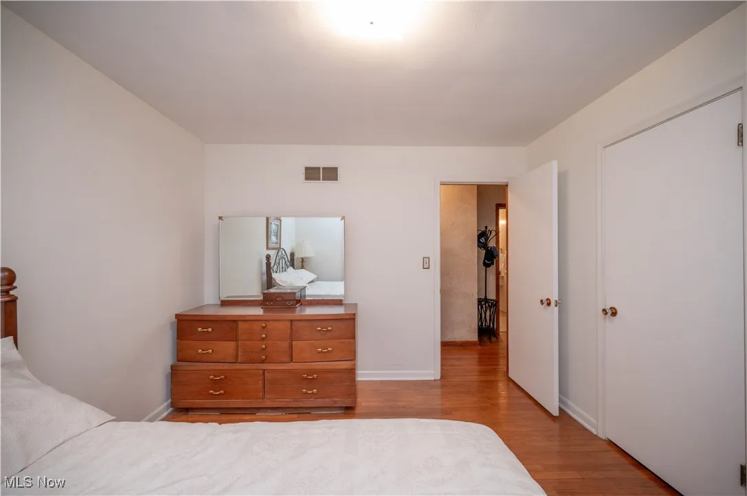 Bedroom with wood finished floors and baseboards