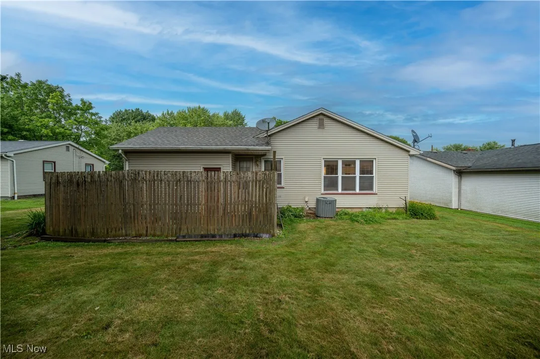 Rear view of house featuring privacy fenced in patio