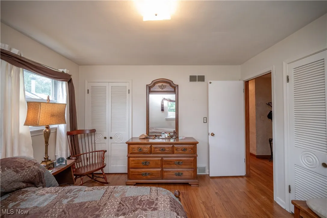 Bedroom with light wood-style floors and baseboards featuring two closet​​‌​​​​‌​​‌‌​‌‌​​​‌‌​‌​‌​‌​​​‌​​ spaces
