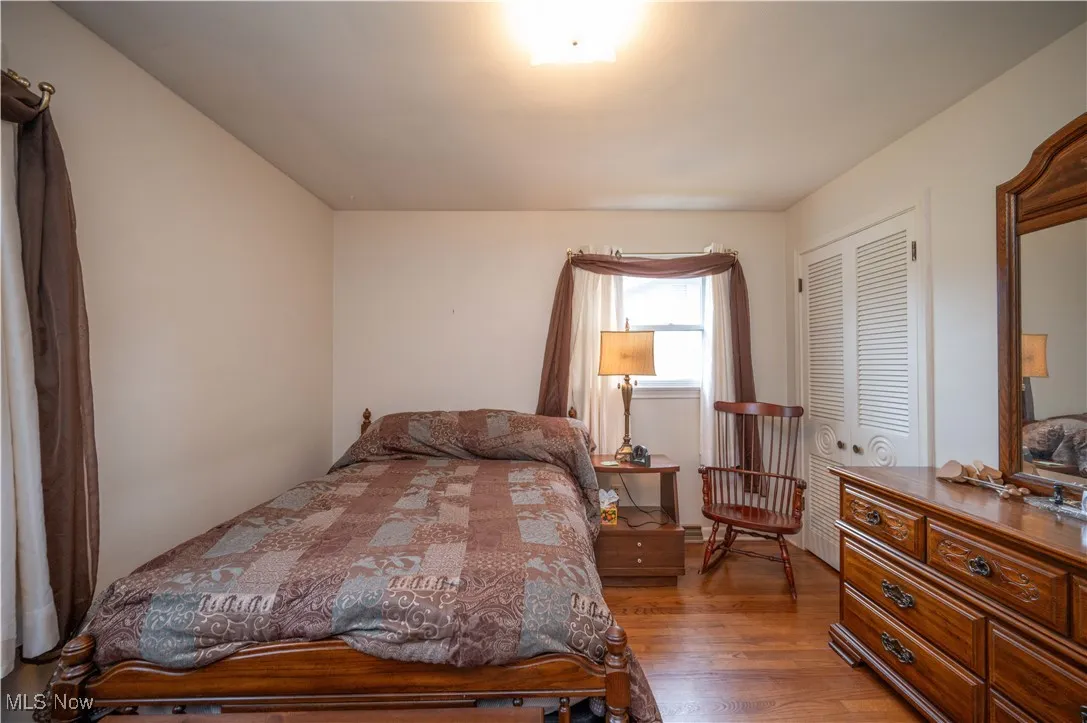 Bedroom featuring wood finished floors and a closet