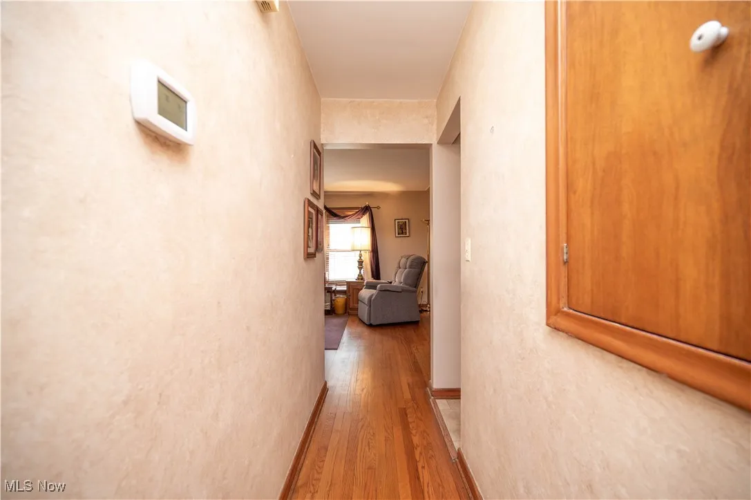 Hall featuring wood finished floors and storage on wall