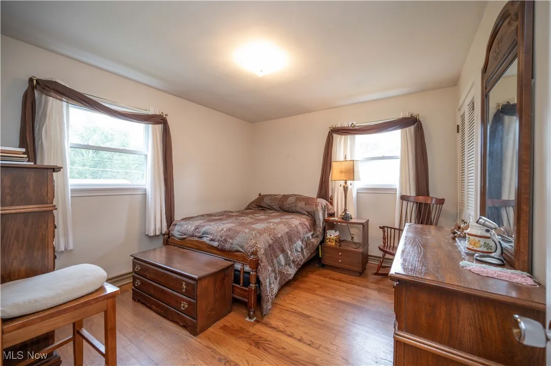 Bedroom with light wood-style flooring and multiple windows