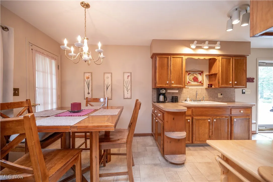 Eat-in kitchen with a chandelier and light linoleum patterned floors