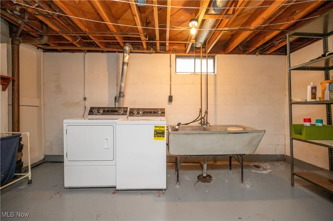 Laundry area featuring washing machine, clothes dryer, and stationary tub