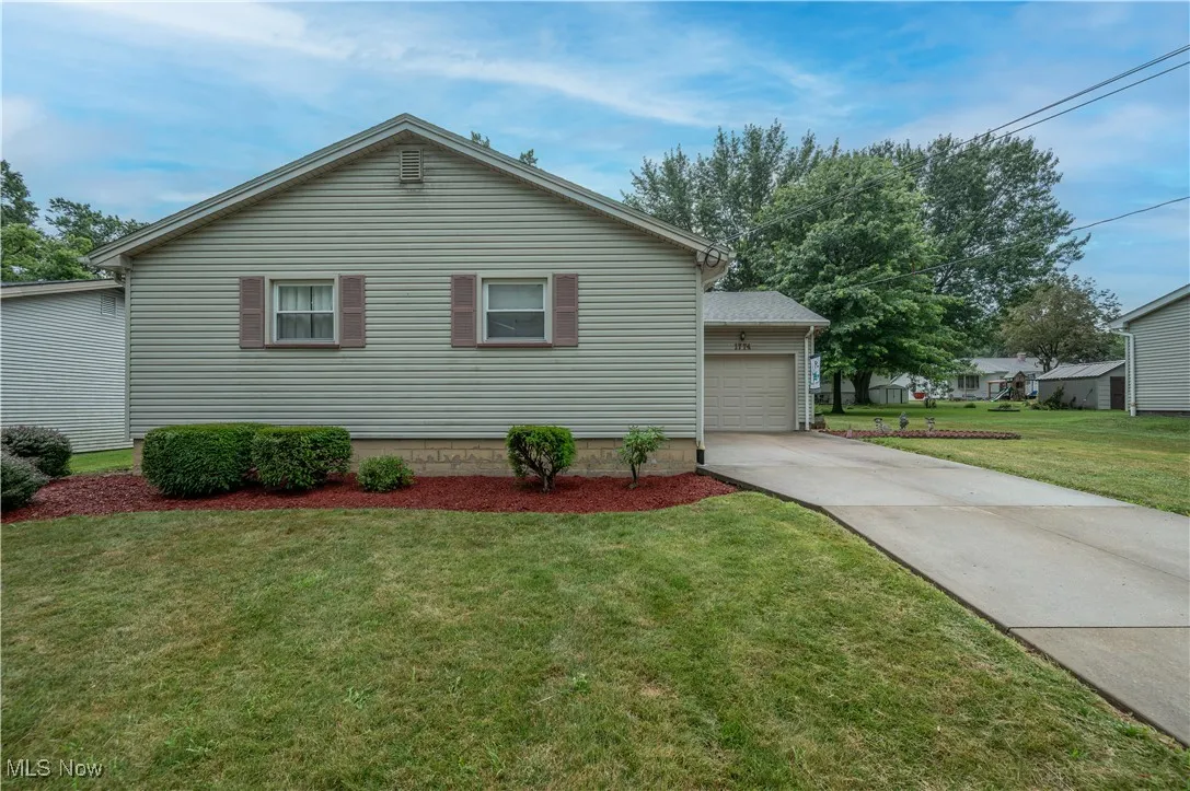 Front of property featuring concrete driveway and a yard