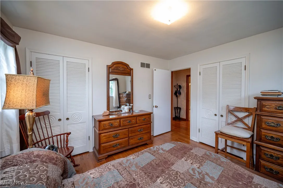 Bedroom with two closets and wood finished floors