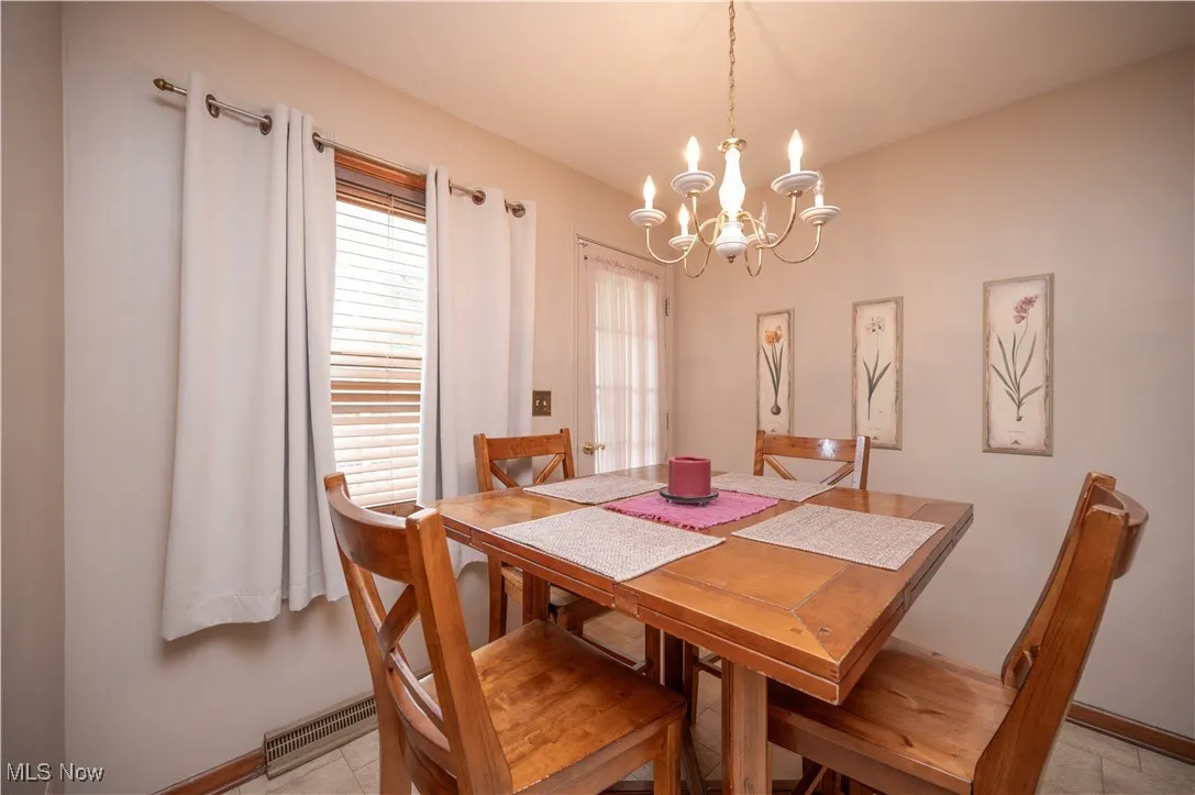 Dining space with a chandelier and baseboards